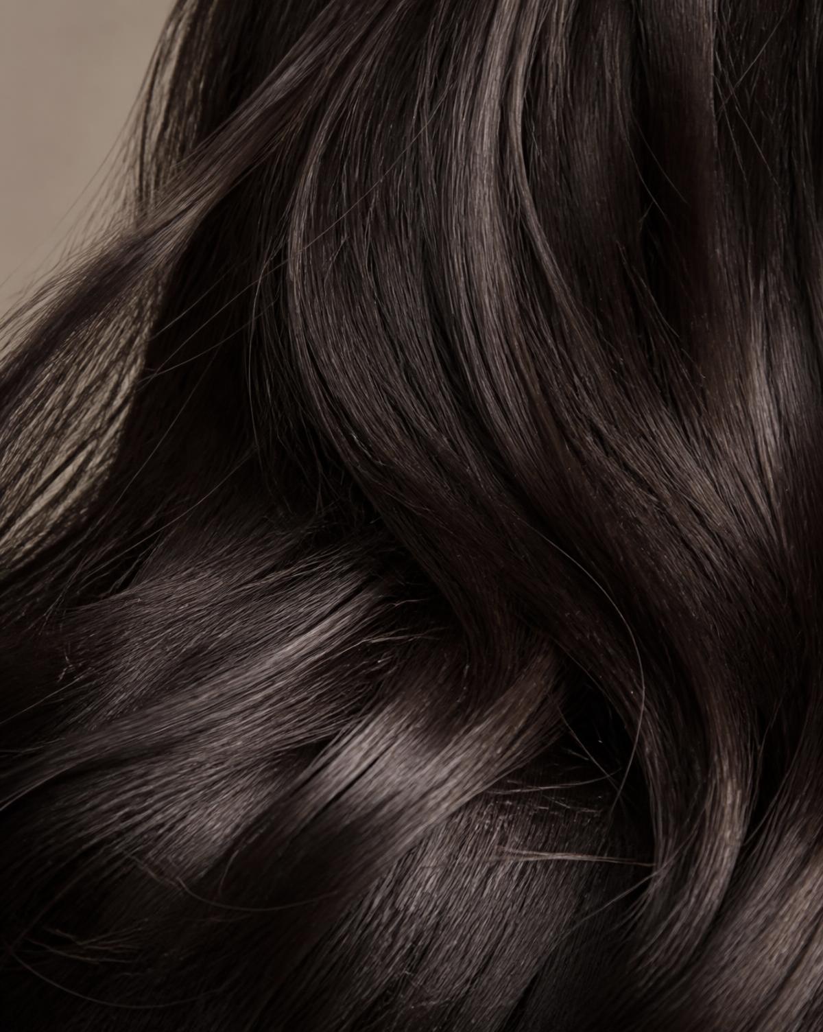 Close-up of glossy human hair extensions showing natural strand texture and shine
